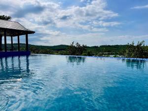 a large pool of blue water with a gazebo at La Vela Legacy Resort in Thôn Dương Xuân Hạ