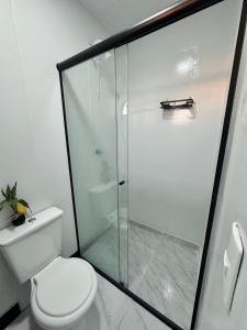 a bathroom with a toilet and a glass shower at Hospedagem Morro do Buda Container in Planalto +24 photos
