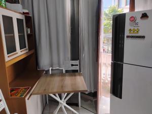 a kitchen with a refrigerator and a wooden table at Hostel vila nova in Niterói