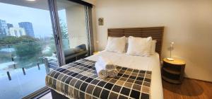 シドニーにあるSweeping Harbour & Ocean Views Over Sydney's Eastの窓のある大きなベッドのある寝室