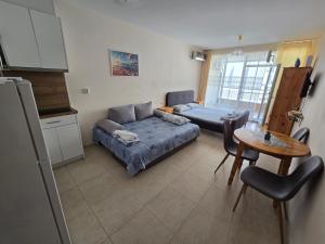 a living room with a couch and a table at Студиa Блу минута от плажа in Pomorie