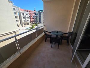 a balcony with a table and chairs and a window at Студиa Блу минута от плажа in Pomorie