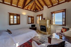 - une chambre avec un lit et une cheminée dans l'établissement Malvasia Traditional Hotel, à Monemvasia