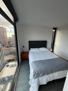 a bedroom with a large bed and a large window at Hermoso Apartamento Equilibrium 1509 in Bogotá +27 photos