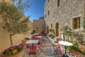 un patio avec des tables et des chaises à côté d'un bâtiment dans l'établissement Malvasia Traditional Hotel, à Monemvasia