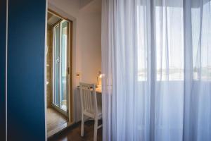 a room with a crib and a window with curtains at Hotel Raffaello in Bellaria-Igea Marina +126 photos