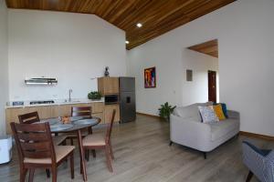 a kitchen and living room with a table and a couch at Nambí Monteverde in Monteverde Costa Rica