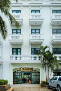 een wit gebouw met een auto ervoor geparkeerd bij JOLLIE HOTEL Phú Quốc in Phu Quoc