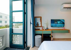 een slaapkamer met een bureau, een computer en een raam bij JOLLIE HOTEL Phú Quốc in Phu Quoc