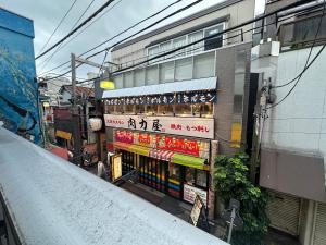 a store with signs on the side of a building at West Shinjuku Nakano Family Inn in Tokyo