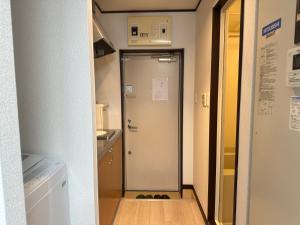 a hallway with a door leading to a kitchen at West Shinjuku Nakano Family Inn in Tokyo +15 photos