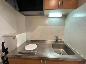a small kitchen with a sink and a toilet at West Shinjuku Nakano Family Inn in Tokyo