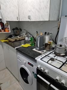 a kitchen with a stove and a washing machine at Hotel Life in Jermuk