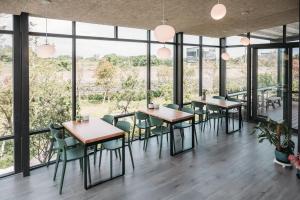a restaurant with tables and chairs and large windows at 棲閑民宿 in Yuanshan
