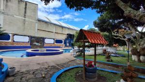a swimming pool in a yard with a building at Villa Confort Hotel in La Mesa