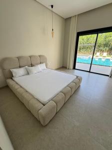 a large bed in a room with a large window at La Villa K Marrakech jacuzzi chauffé in Marrakech +58 photos