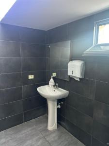 a bathroom with a white sink and a window at Bar Hotel Orgito in Lushnjë +1 photo