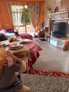 a living room with a table and a tv at Deluxe garden flat near Terra-Mítica in Benidorm
