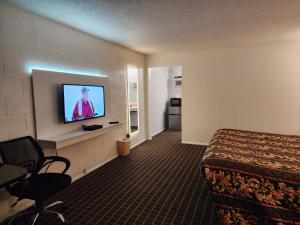 Una habitación de hotel con una cama y un televisor de pantalla plana. en Holiday Lodge, en Hawthorne 14 fotos más