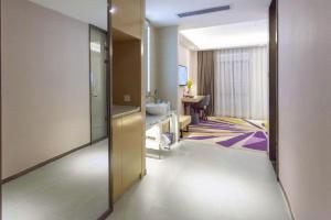 een kamer met een badkamer met een wastafel en een spiegel bij Lavande Hotel Huizhou Shiwan in Shiwan