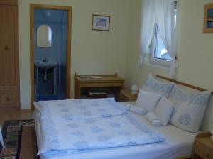 1 dormitorio con 1 cama blanca grande y lavamanos en Zsuzsanna Ház, en Hévíz