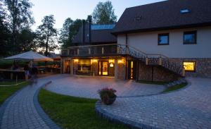 una casa con un patio de ladrillo junto a un edificio en Sodyba Ignė en Druskininkai