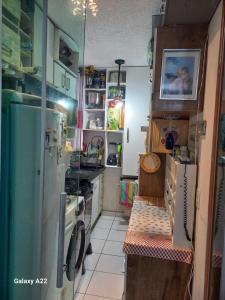 a small kitchen with a refrigerator and a stove at apartamento cop30 in Ananindeua