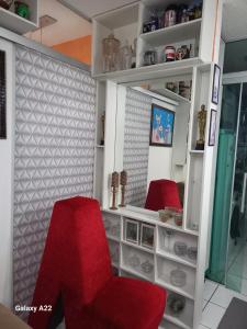 a living room with two red chairs and shelves at apartamento cop30 in Ananindeua +1 photo