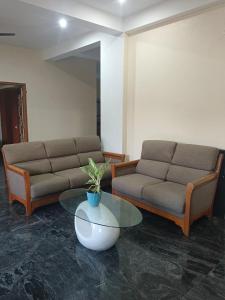 a living room with two couches and a table at perumal home stay in Tiruvannāmalai
