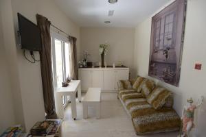 a living room with a couch and a tv at Fantastic Matala 2 in Matala