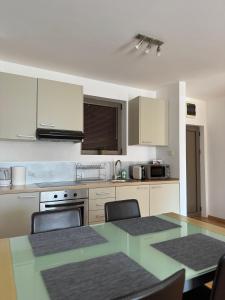 a kitchen with white cabinets and a table with chairs at Infinity Apartment Blue Horizont Przno in Kravlja
