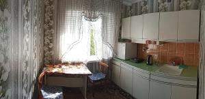 Una pequeña cocina con fregadero y ventana. en Квартира абдрахманова, en Karakol 1 foto más