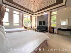Un dormitorio grande con dos camas y un televisor. en 夢幻城堡民宿, en Wujie