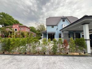 a group of houses with flowers in a yard at Eiffel Villa Homestay in Simpang Empat