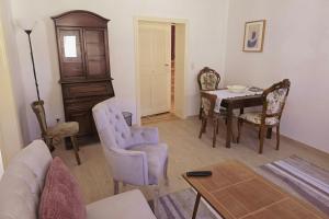 a living room with a couch and a table and chairs at Haus Marienblick in Beeskow +4 photos