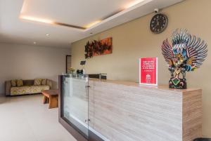 a lobby with a counter with a clock on the wall at Mi Casa Residence in Seminyak