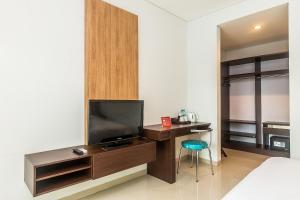 a bedroom with a television and a desk with a chair at Mi Casa Residence in Seminyak