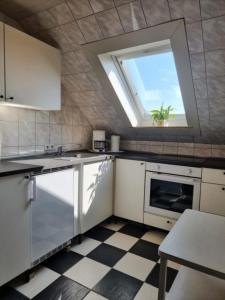 a kitchen with white appliances and a window at Ferienwohnung zur Forelle - Idyllischer Hof im Grünen in Wester-Ohrstedt