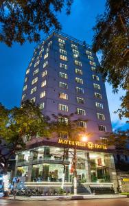 een hoog gebouw met een bord ervoor bij May De Ville Trendy Hotel & Spa in Hanoi