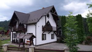 a large white house with a black roof at Olko House in Yaremche