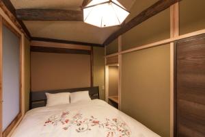 a bedroom with a bed and a light at Machiya Maya Gion in Kyoto