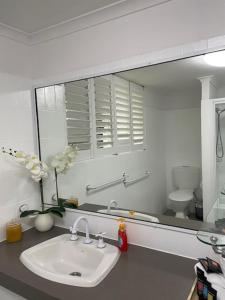 a bathroom with a sink and a large mirror at Horizons 1 in Bargara
