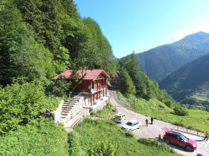 a building on the side of a hill with cars at Ozturk Apart in Uzungöl