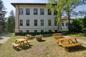 un groupe de tables de pique-nique devant un bâtiment dans l'établissement Hostel Valtice, à Valtice