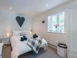 una camera da letto con un letto con cuscini blu di Puddle Duck Cottage a Kendal Altre 7 foto