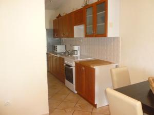 a kitchen with wooden cabinets and a white stove top oven at Luna Apartments in Trogir