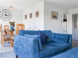 a blue couch in a living room with a table at The Bungalow in Staithes