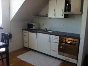 a kitchen with white cabinets and a sink and a stove at Andro studio apartment in Ljubljana