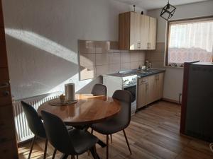 a small kitchen with a wooden table and chairs at Jovan in Šipovo +21 photos