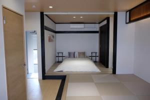 a bedroom with a bed in the middle of a room at Jasmin錦町5-6 高松駅近 2階層 テラス付き in Takamatsu